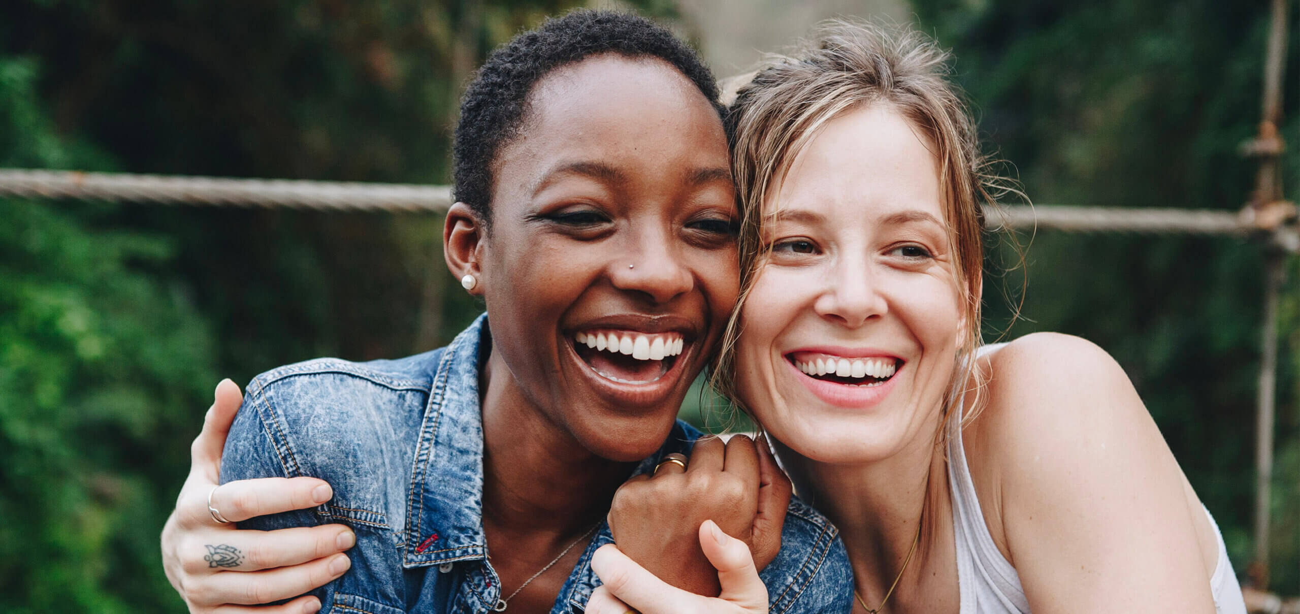 Two women smiling with joy after getting the treatment for dental implants at Arnold Dental in Nottingham