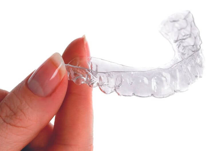 woman holding an Invisalign mouth guard