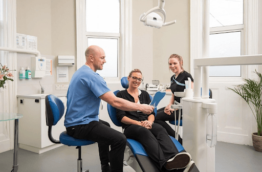 A person looking at her front teeth during a consultation with a dentist.